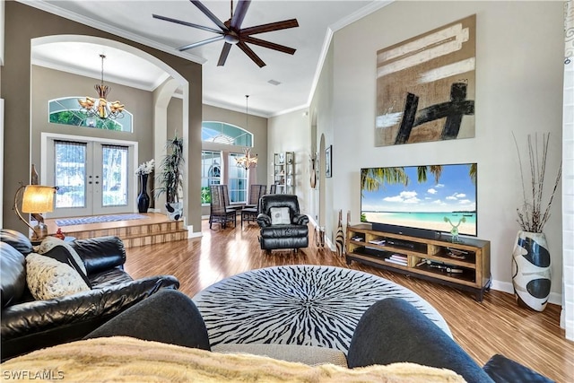 living room with hardwood / wood-style flooring, a high ceiling, a notable chandelier, and french doors