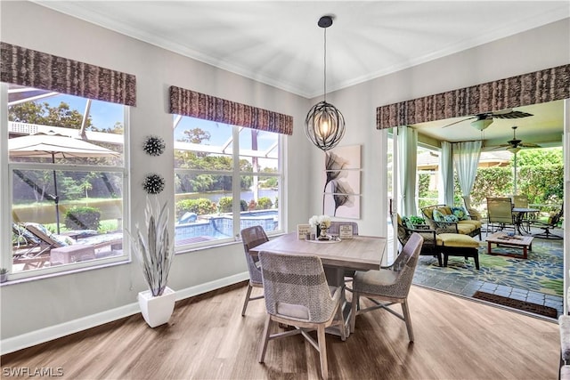 dining room with hardwood / wood-style floors, crown molding, and plenty of natural light