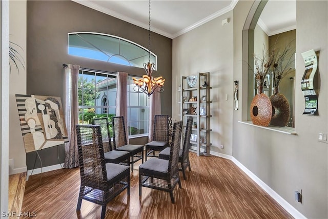 dining room with crown molding, hardwood / wood-style flooring, and a chandelier