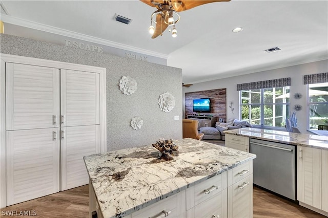 kitchen featuring dishwasher, white cabinetry, a center island, light stone counters, and ornamental molding