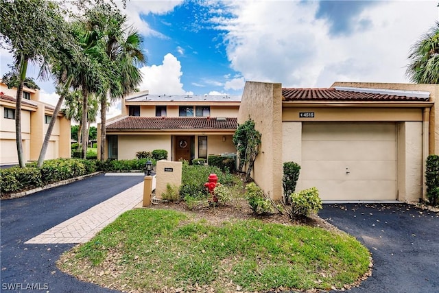 4515 Windjammer Ln, Fort Myers, FL 33919 - townhome / multi-family property featuring stucco siding, a tile roof, aphalt driveway, and a garage