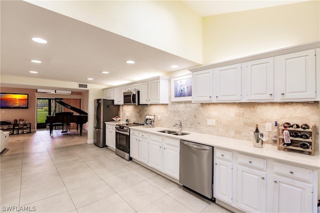 kitchen featuring appliances with stainless steel finishes, light tile patterned floors, white cabinets, and sink