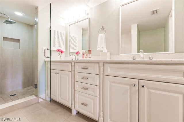 bathroom with tile patterned flooring, an enclosed shower, and double vanity