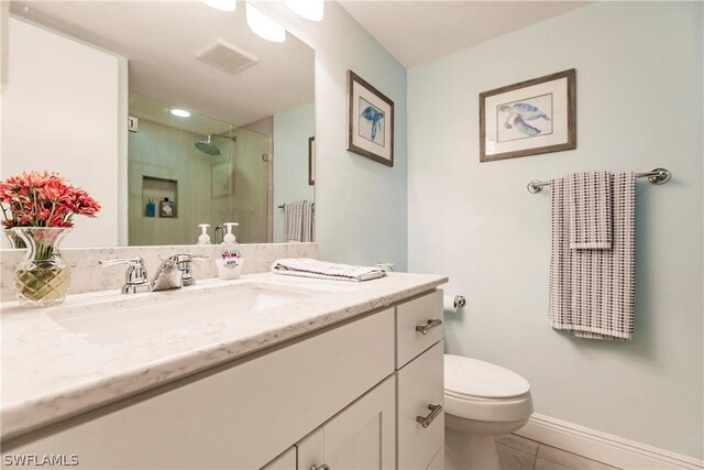 bathroom with vanity, toilet, and a shower with shower door