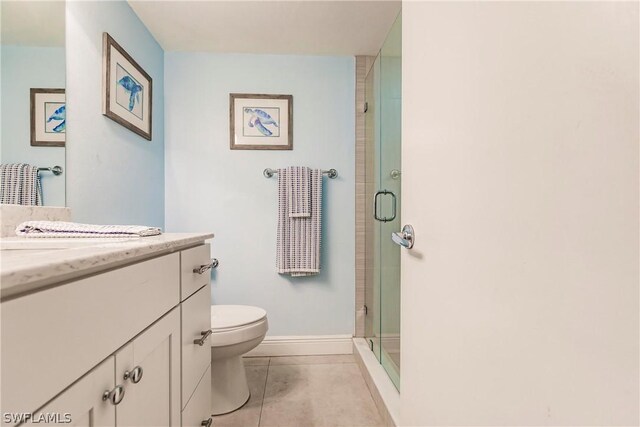 bathroom with vanity, tile patterned floors, toilet, and walk in shower