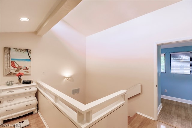 corridor featuring light hardwood / wood-style floors and lofted ceiling with beams