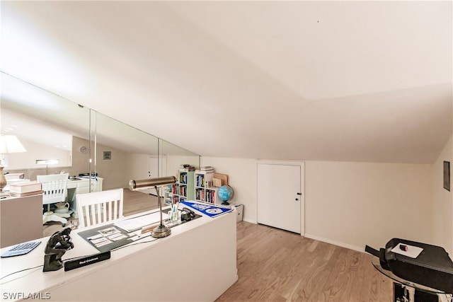 home office with light hardwood / wood-style flooring and vaulted ceiling