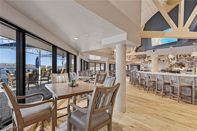 dining room with bar area and light hardwood / wood-style flooring