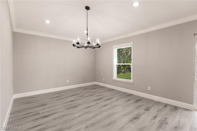 empty room featuring crown molding, a chandelier, and light hardwood / wood-style floors