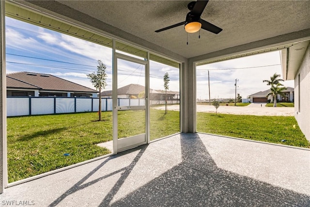 unfurnished sunroom featuring ceiling fan