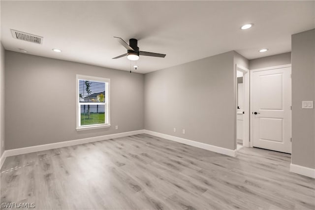 spare room with ceiling fan and light wood-type flooring