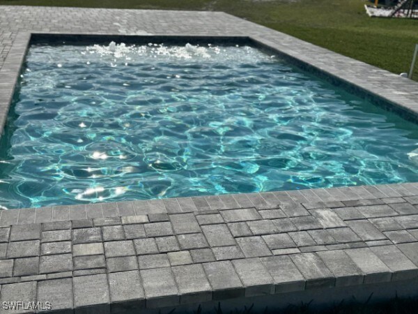 view of swimming pool with a hot tub and a lawn