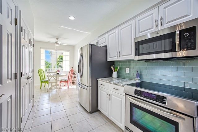 kitchen featuring ceiling fan, white cabinets, light tile patterned floors, and stainless steel appliances