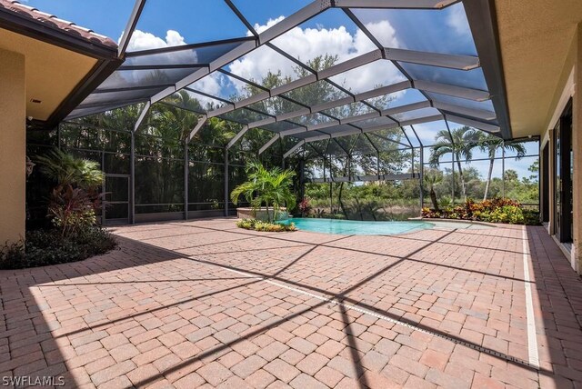 view of swimming pool with a patio and glass enclosure