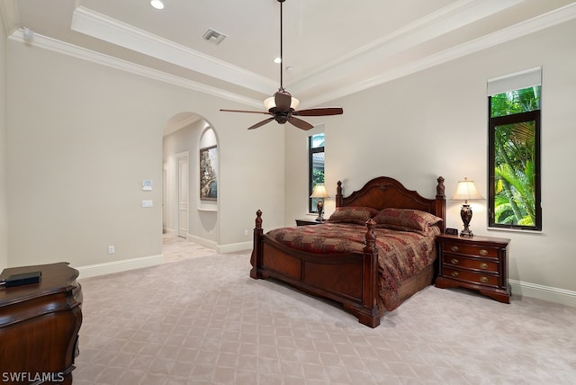 bedroom with ceiling fan, light carpet, a raised ceiling, and crown molding