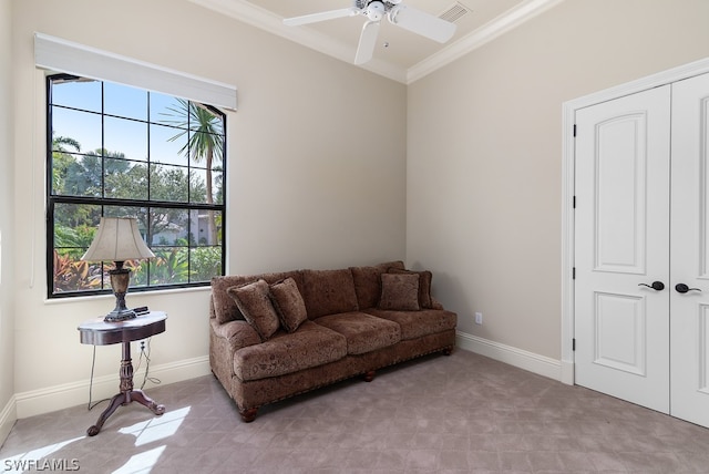 living area with ceiling fan and ornamental molding