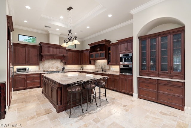 kitchen featuring dark brown cabinetry, backsplash, crown molding, and a center island