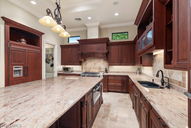 kitchen featuring ornamental molding, light stone counters, sink, and decorative light fixtures