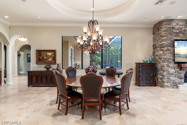 dining area with ornate columns, crown molding, and a tray ceiling