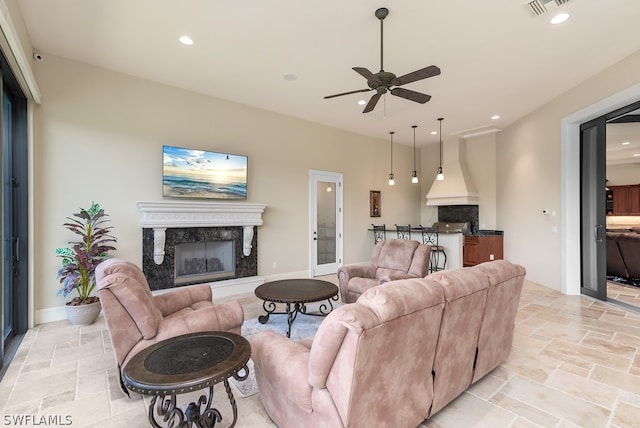 living room with a fireplace and ceiling fan