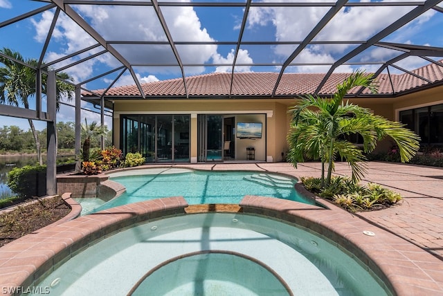 view of swimming pool featuring a patio, glass enclosure, and an in ground hot tub