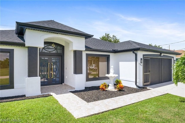 entrance to property featuring french doors, a yard, stucco siding, a shingled roof, and a garage