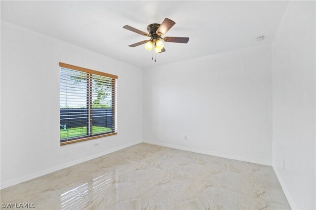 tiled spare room with ceiling fan