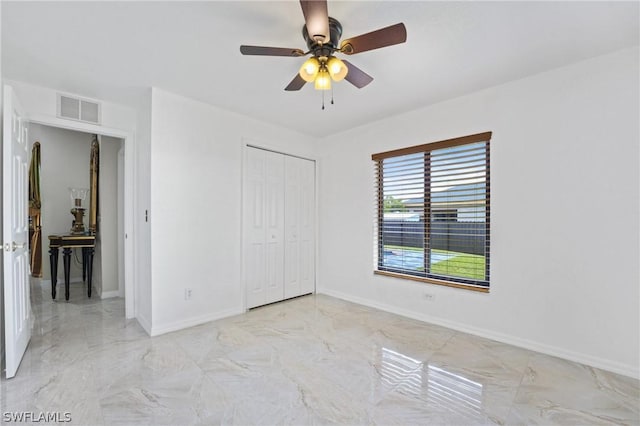 unfurnished bedroom with marble finish floor, a closet, visible vents, ceiling fan, and baseboards