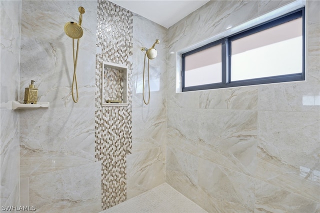 bathroom with a tile shower and a healthy amount of sunlight