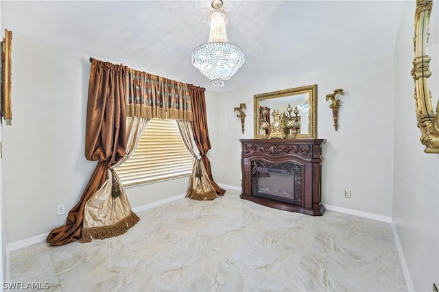 sitting room featuring a chandelier, a glass covered fireplace, marble finish floor, and baseboards