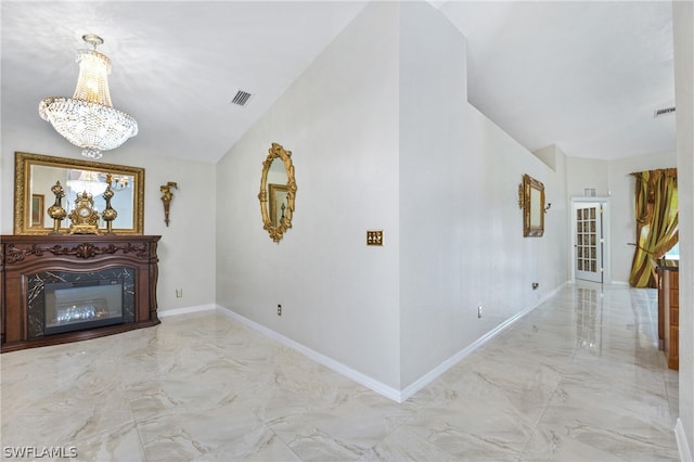 hall with tile patterned flooring and a notable chandelier