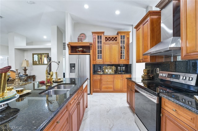 kitchen featuring stainless steel appliances, wall chimney range hood, backsplash, light tile patterned floors, and dark stone countertops