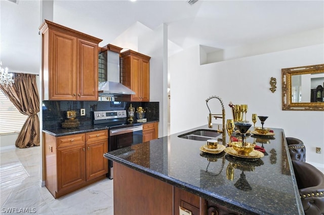 kitchen with brown cabinets, stainless steel electric range oven, a sink, wall chimney range hood, and dark stone counters