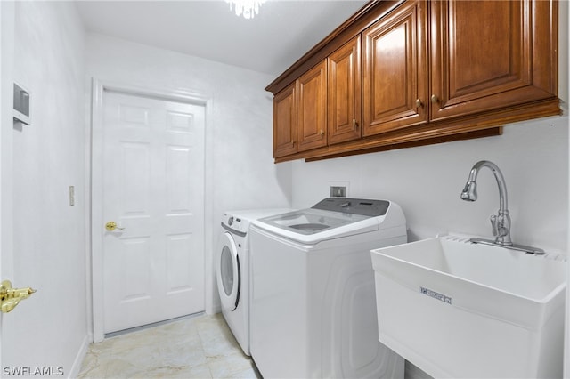 washroom featuring light tile patterned floors, washing machine and clothes dryer, sink, and cabinets