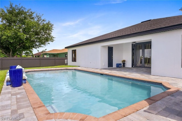 view of swimming pool featuring a patio area, fence, a fenced in pool, and french doors