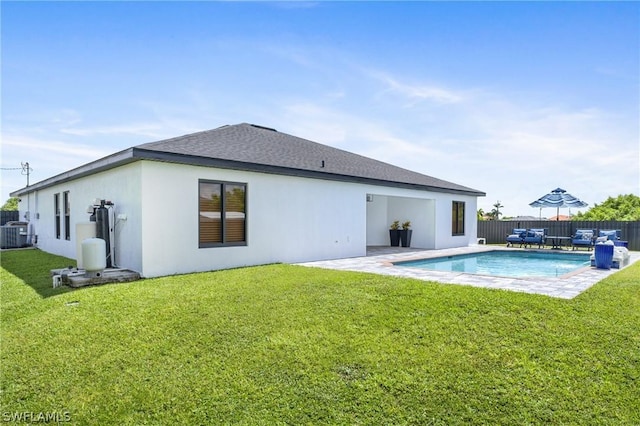 rear view of property featuring a lawn, a fenced backyard, a fenced in pool, and stucco siding