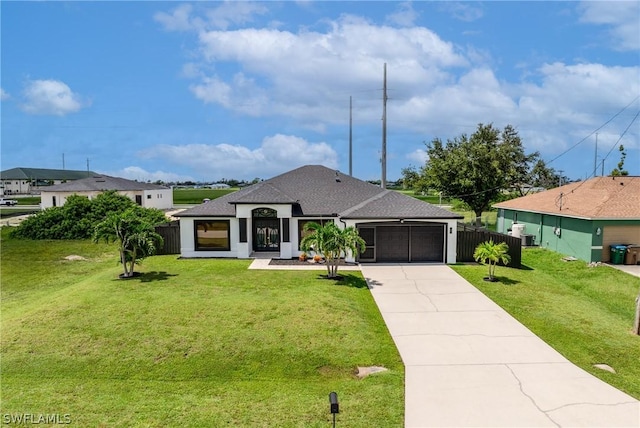 view of front of property featuring a shingled roof, a front yard, fence, a garage, and driveway