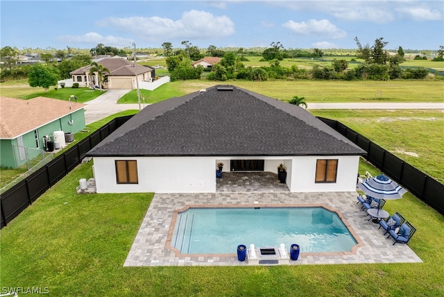 rear view of property with a patio area, a fenced in pool, and a lawn