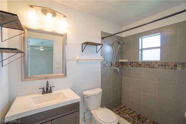 bathroom featuring vanity, tiled shower, and toilet