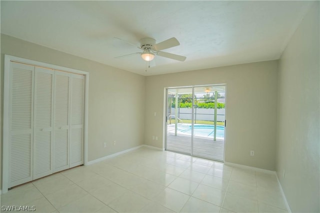 unfurnished bedroom with light tile patterned floors, access to outside, a closet, and ceiling fan