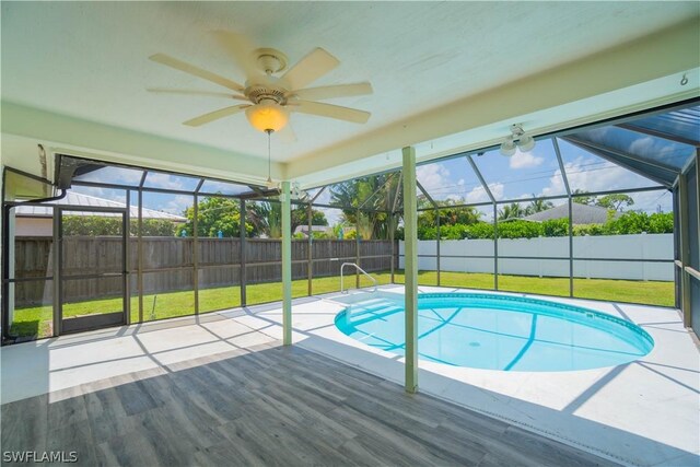 view of swimming pool with a yard, a lanai, and ceiling fan