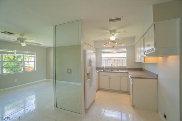 kitchen with white cabinetry, white refrigerator with ice dispenser, sink, and light tile patterned floors