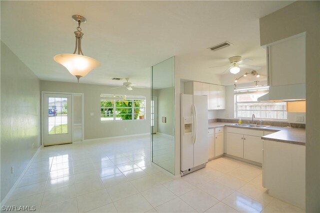 kitchen featuring white cabinetry, sink, light tile patterned floors, and white refrigerator with ice dispenser