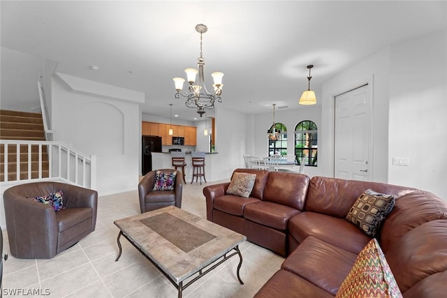 living area featuring light tile patterned floors, stairs, and a chandelier