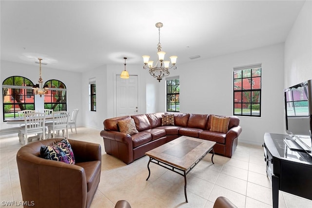 living room featuring a chandelier, visible vents, baseboards, and light tile patterned flooring