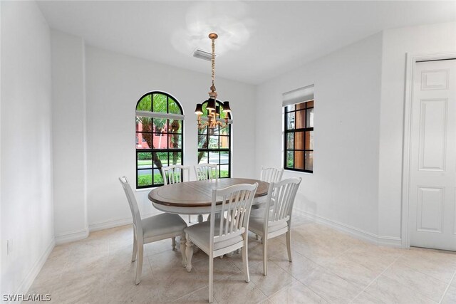 dining space featuring light tile patterned flooring and a chandelier