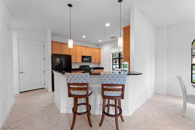 kitchen featuring light tile patterned floors, black appliances, kitchen peninsula, and a kitchen breakfast bar