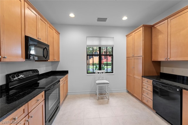 kitchen featuring dark stone countertops, light tile patterned flooring, and black appliances