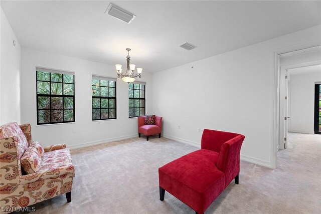 living area featuring a notable chandelier and light colored carpet