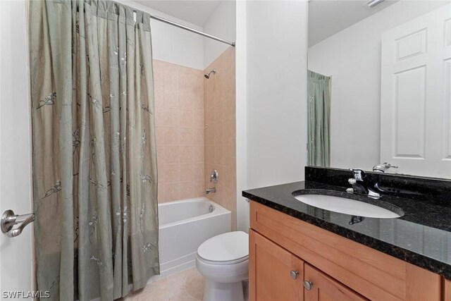 full bathroom featuring tile patterned flooring, shower / bath combo with shower curtain, toilet, and vanity